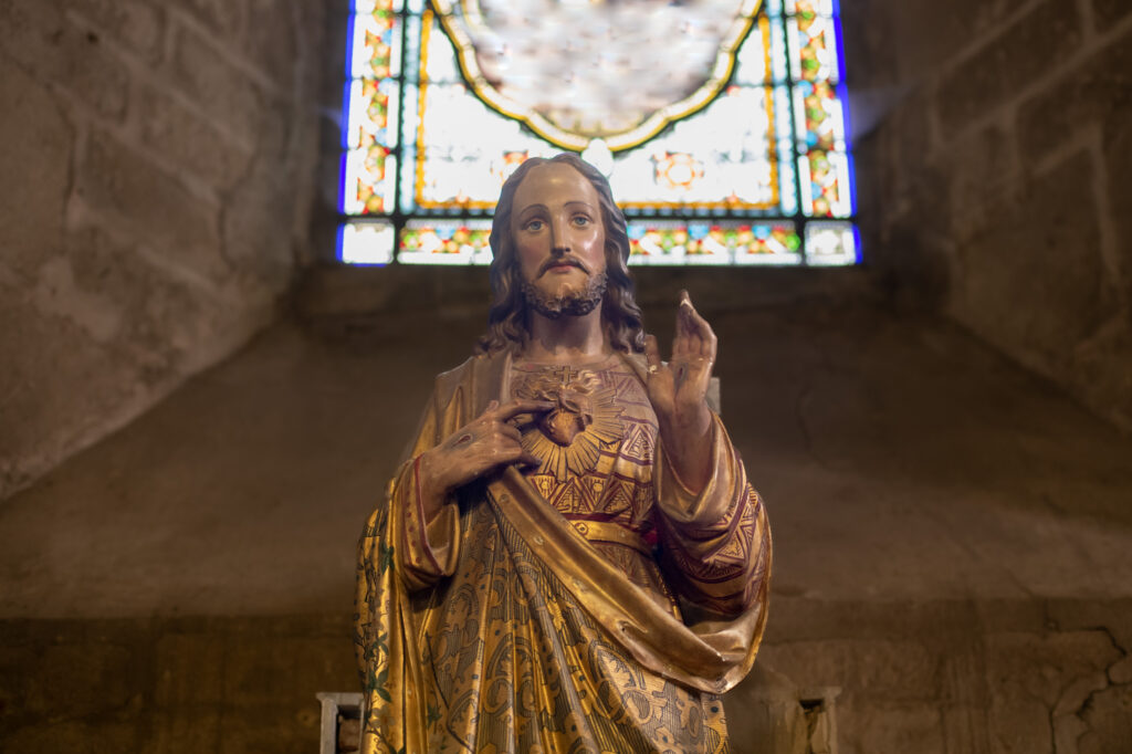 Statue of Jesus with a red heart. Photographed by o1559kip. Used under license by Adobe Stock.