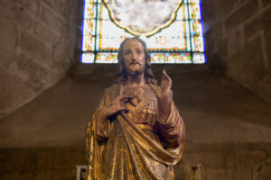 Statue of Jesus with a red heart. Photographed by o1559kip. Used under license by Adobe Stock.