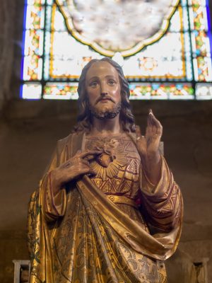 Statue of Jesus with a red heart. Photographed by o1559kip. Used under license by Adobe Stock.