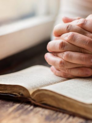 Unrecognizable,Woman,Holding,A,Bible,In,Her,Hands,And,Praying